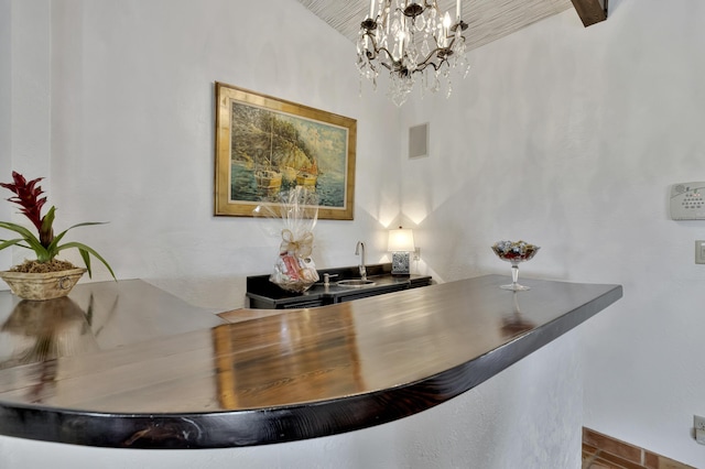 interior space featuring decorative light fixtures, vaulted ceiling, sink, and an inviting chandelier