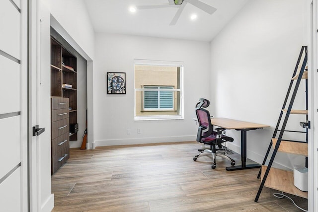 home office with light hardwood / wood-style floors and ceiling fan