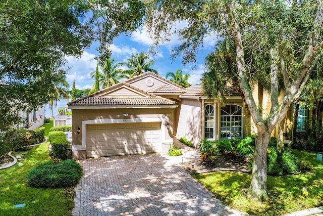 mediterranean / spanish home featuring a garage and a front yard