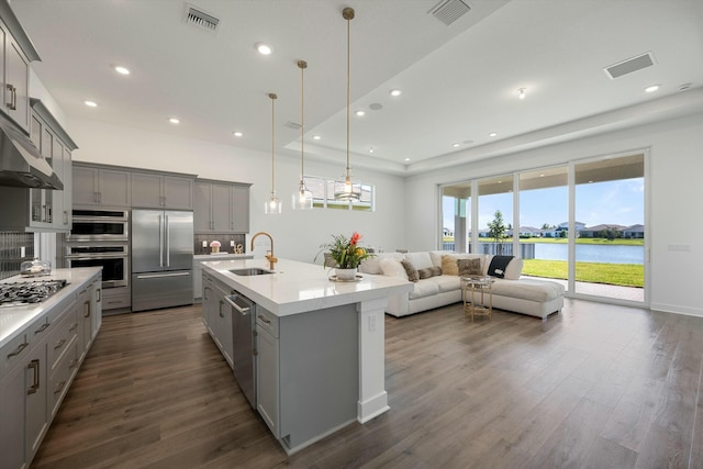 kitchen featuring sink, a water view, gray cabinetry, and stainless steel appliances