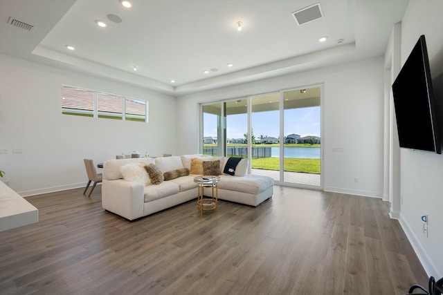 living room featuring a raised ceiling and hardwood / wood-style flooring