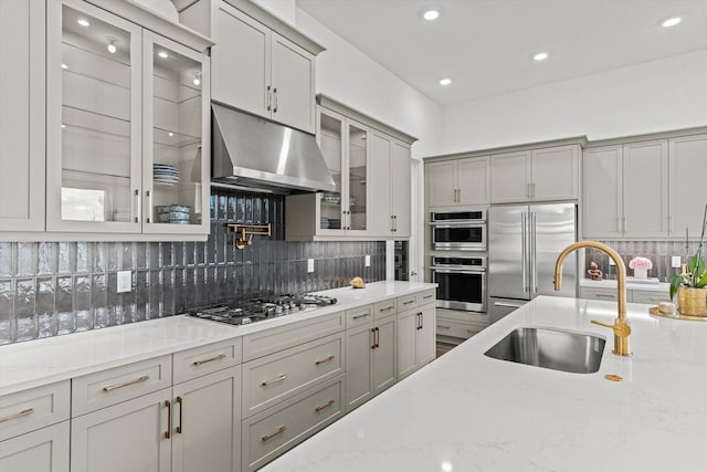 kitchen featuring gray cabinetry, sink, appliances with stainless steel finishes, tasteful backsplash, and light stone counters