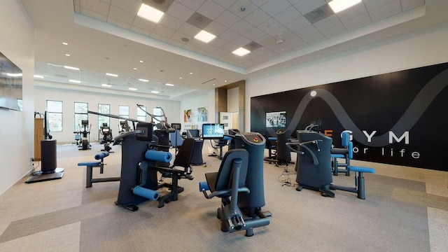 workout area featuring light carpet, a tray ceiling, and a drop ceiling