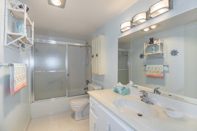 full bathroom featuring combined bath / shower with glass door, vanity, toilet, and tile patterned floors