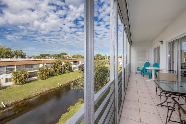 6289 Lear Dr Unit 301, Lake Worth, FL 33462 - sunroom featuring tile patterned floors, a wealth of natural light, and a water view