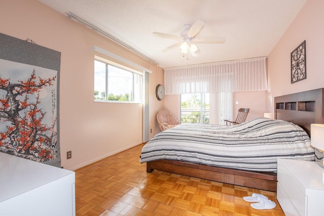 bedroom featuring light parquet floors, a textured ceiling, and ceiling fan