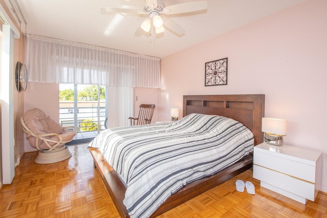 bedroom with ceiling fan, light parquet floors, and access to exterior