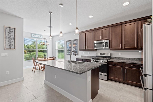 kitchen with a center island with sink, stainless steel appliances, plenty of natural light, and sink