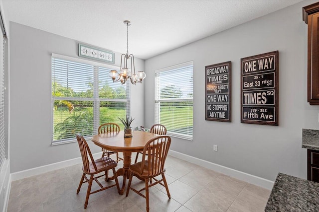 dining area with a notable chandelier, a textured ceiling, plenty of natural light, and light tile patterned flooring