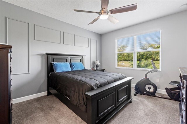 carpeted bedroom with ceiling fan and a textured ceiling