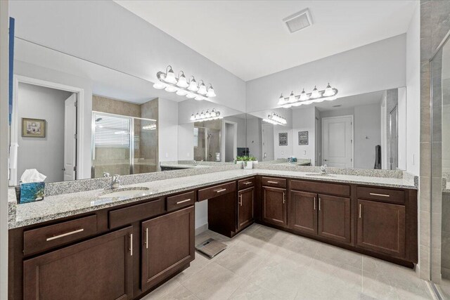 bathroom featuring vanity, tile patterned floors, and a shower with door