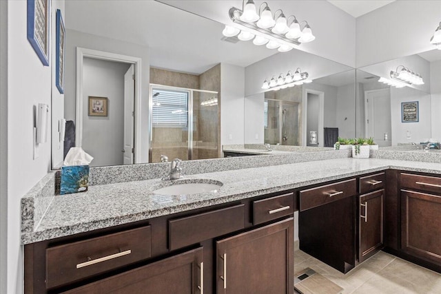 bathroom with vanity, a shower with shower door, and tile patterned flooring