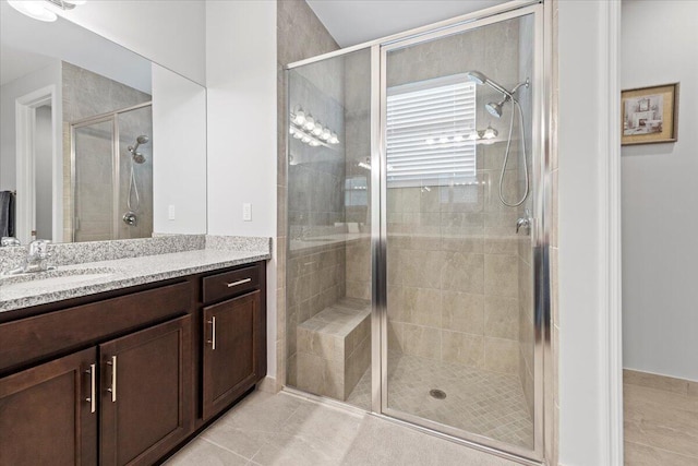 bathroom with tile patterned flooring, vanity, and a shower with door