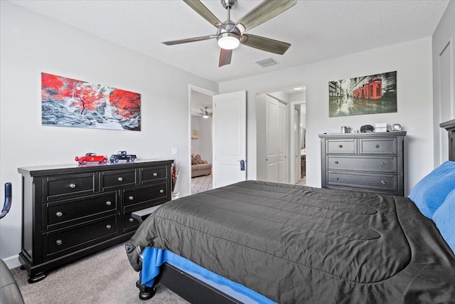 carpeted bedroom featuring a textured ceiling and ceiling fan