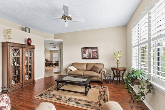 living room with dark hardwood / wood-style floors, ceiling fan, and a wealth of natural light