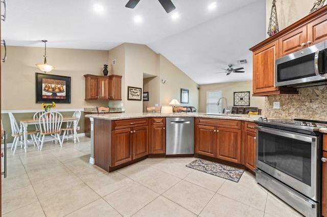 kitchen featuring appliances with stainless steel finishes, kitchen peninsula, light stone countertops, ceiling fan, and sink