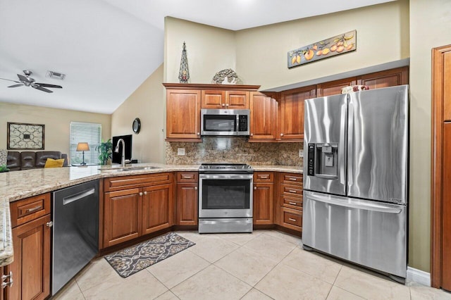 kitchen with tasteful backsplash, sink, lofted ceiling, appliances with stainless steel finishes, and ceiling fan