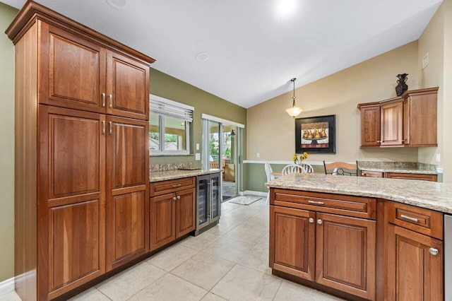 kitchen with pendant lighting, lofted ceiling, light tile patterned floors, beverage cooler, and light stone countertops