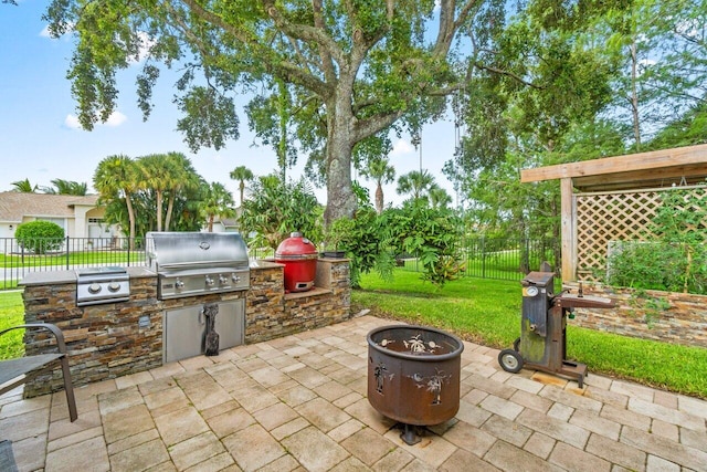 view of patio with grilling area, a fire pit, and exterior kitchen