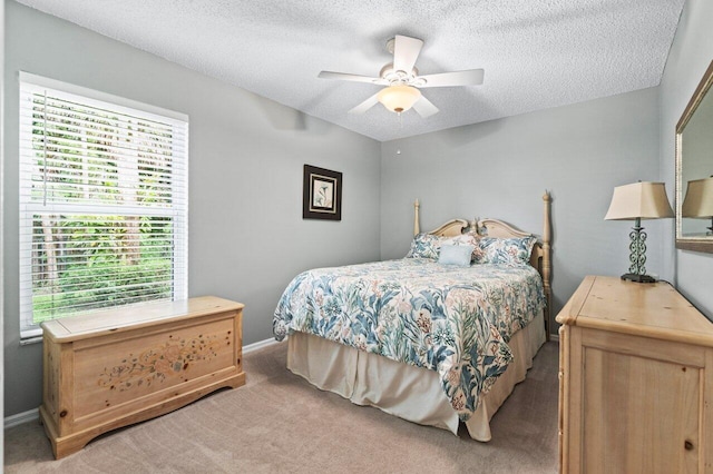 carpeted bedroom featuring a textured ceiling and ceiling fan