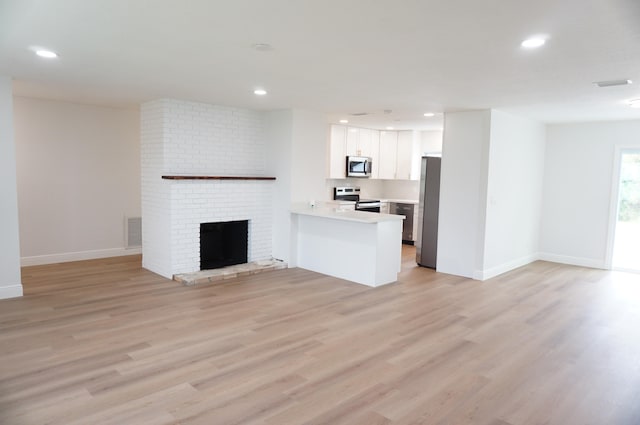 unfurnished living room featuring light hardwood / wood-style flooring and a fireplace