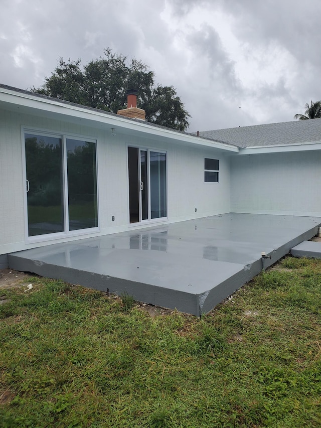 back of property featuring a patio and a yard