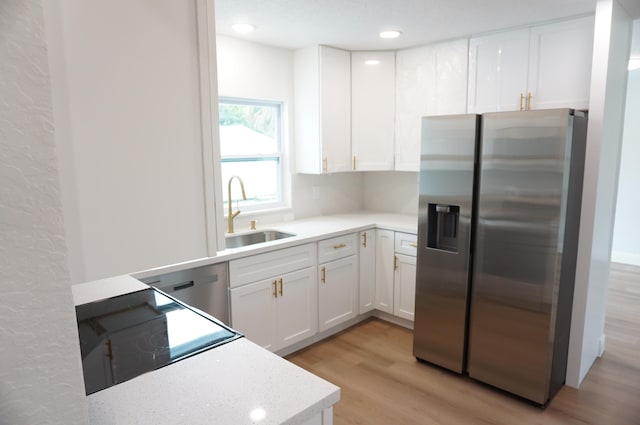 kitchen with sink, stainless steel fridge with ice dispenser, light wood-type flooring, and white cabinetry