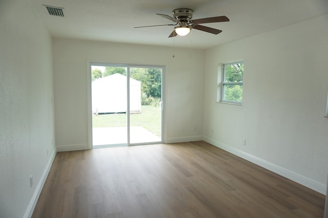 spare room featuring ceiling fan, a healthy amount of sunlight, and light wood-type flooring