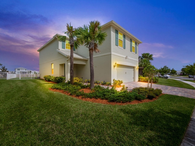 property exterior at dusk featuring a garage and a lawn