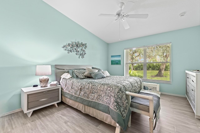 bedroom featuring light wood-type flooring, vaulted ceiling, and ceiling fan