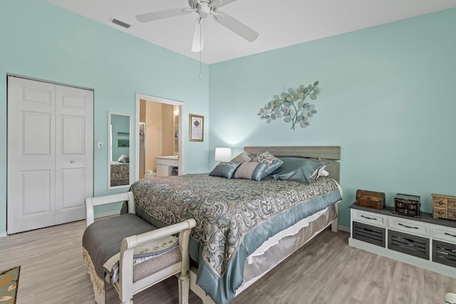 bedroom with ceiling fan, hardwood / wood-style flooring, a closet, and ensuite bath