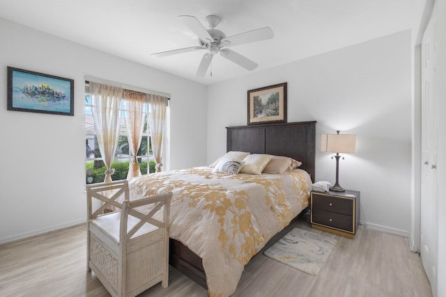 bedroom featuring ceiling fan, light hardwood / wood-style flooring, and a closet