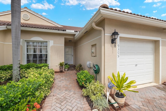 view of exterior entry with a garage