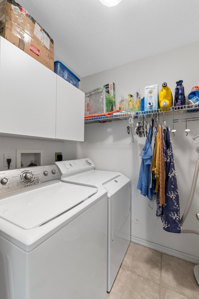 washroom featuring cabinets, a textured ceiling, light tile patterned floors, and washing machine and dryer