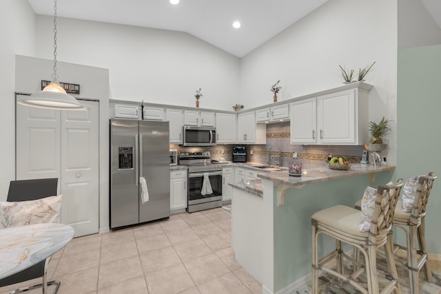 kitchen featuring appliances with stainless steel finishes, sink, pendant lighting, and white cabinets