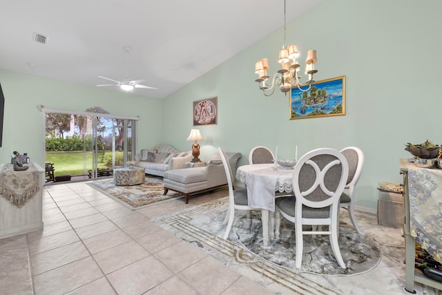 dining area with ceiling fan with notable chandelier, vaulted ceiling, and light tile patterned floors