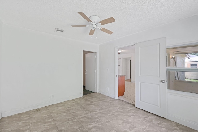 unfurnished room featuring ceiling fan and a textured ceiling