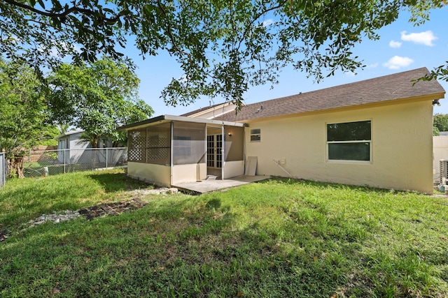 6009 Triphammer Rd, Lake Worth, FL 33463 - rear view of house featuring a sunroom, a yard, stucco siding, and fence