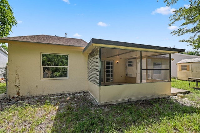6009 Triphammer Rd, Lake Worth, FL 33463 - rear view of property featuring stucco siding, a sunroom, and roof with shingles