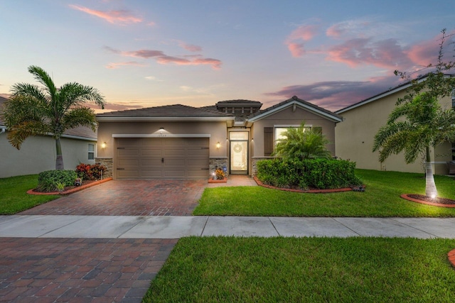 view of front of house featuring a garage and a lawn