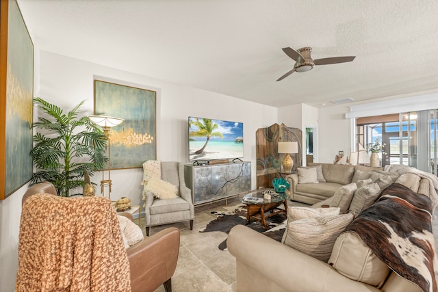 living room with ceiling fan and a textured ceiling