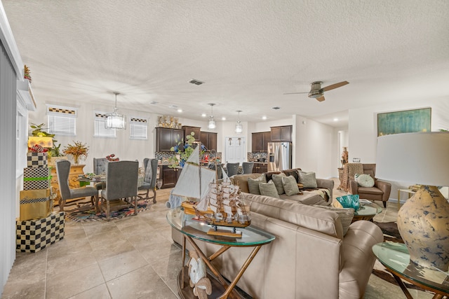 tiled living room with a textured ceiling and ceiling fan