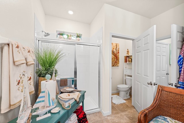 bathroom featuring a shower with door and toilet