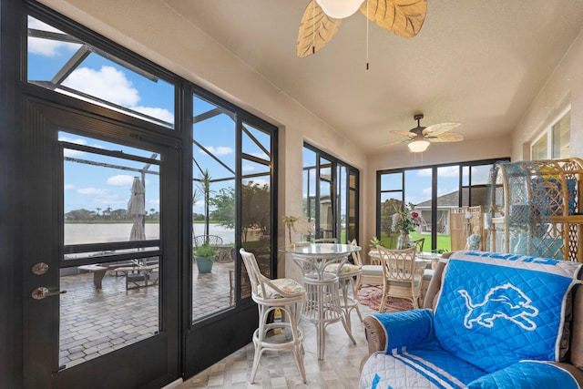 sunroom / solarium with a water view and ceiling fan