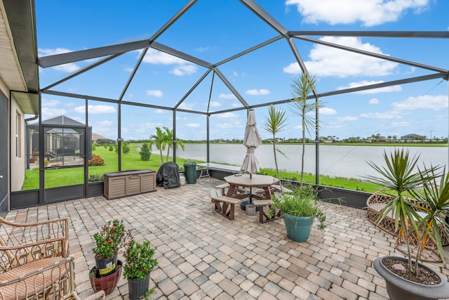 view of patio / terrace featuring a lanai and a water view