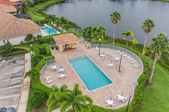 view of pool featuring a water view and a patio