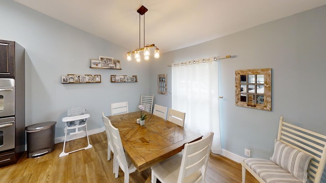 dining area featuring lofted ceiling and light hardwood / wood-style floors