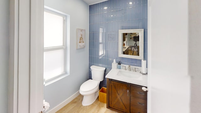 bathroom featuring vanity, toilet, hardwood / wood-style flooring, and a wealth of natural light