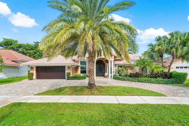 mediterranean / spanish home with a garage and a front yard