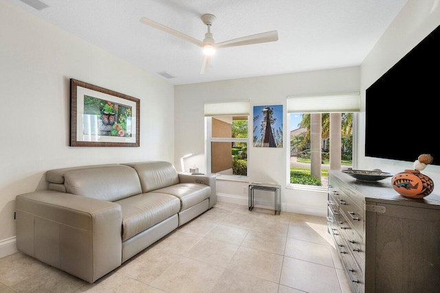 tiled living room featuring ceiling fan and a textured ceiling